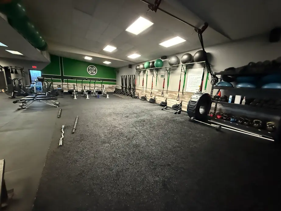 The empty Legacy Fitness training floor in Blaine, with rowers, suspension straps and the green LF wall